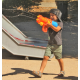 Kind spielt mit Wasserpistole im Sommer